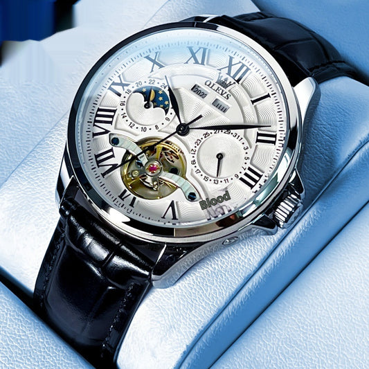 Elegant automatic mechanical men's watch with silver dial and black leather strap showcased on a blue cushion